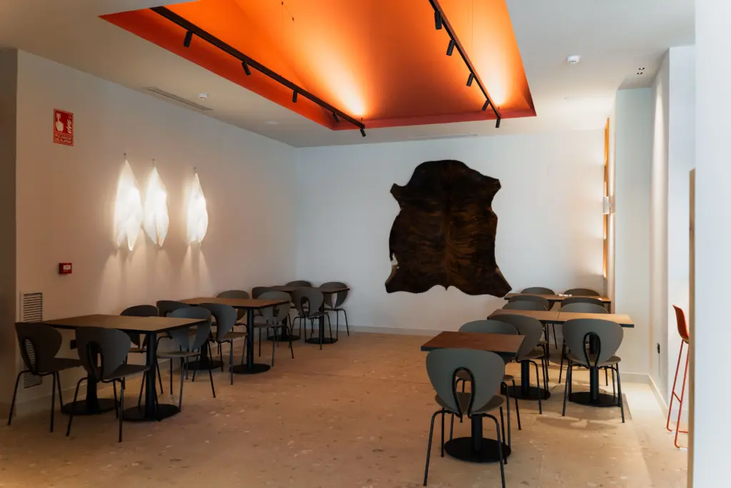 Comedor principal de Chuleteros Lezkairu con piel de vaca decorativa, restaurante en Pamplona